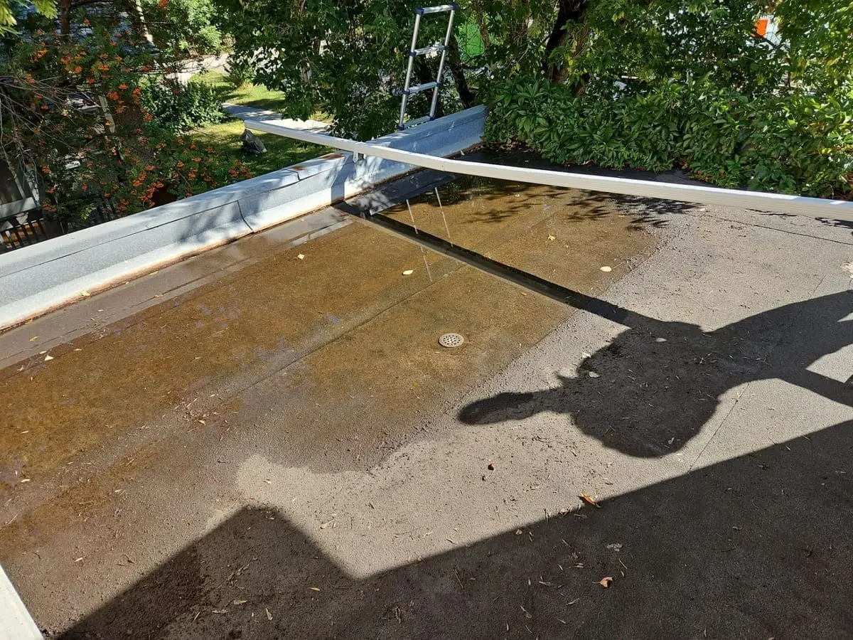 ponding water on a garage flat roof in Calgary caused by clogged drains and insufficient slope
