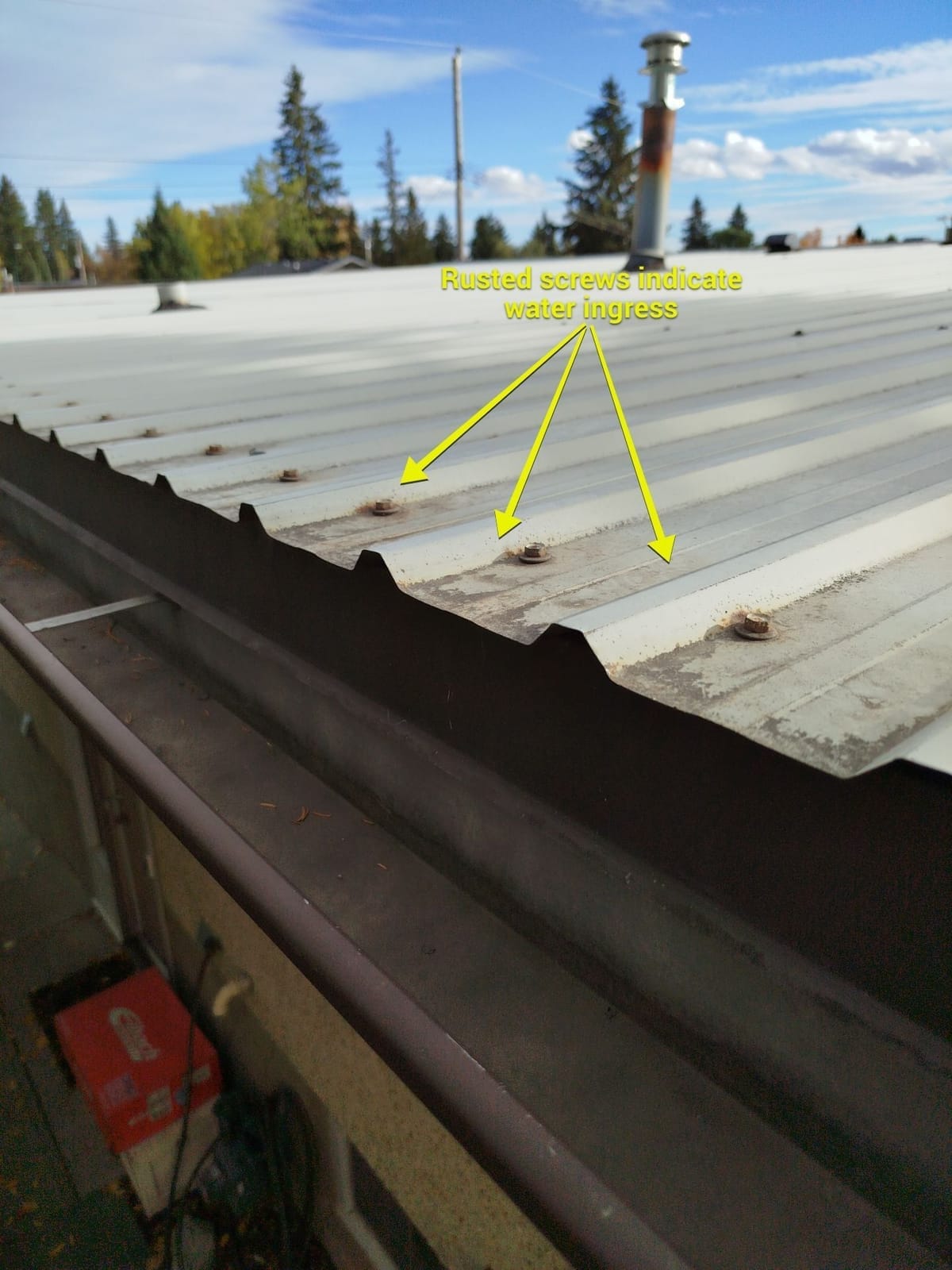 Rusted fasteners from ice damming to metal roof eaves view