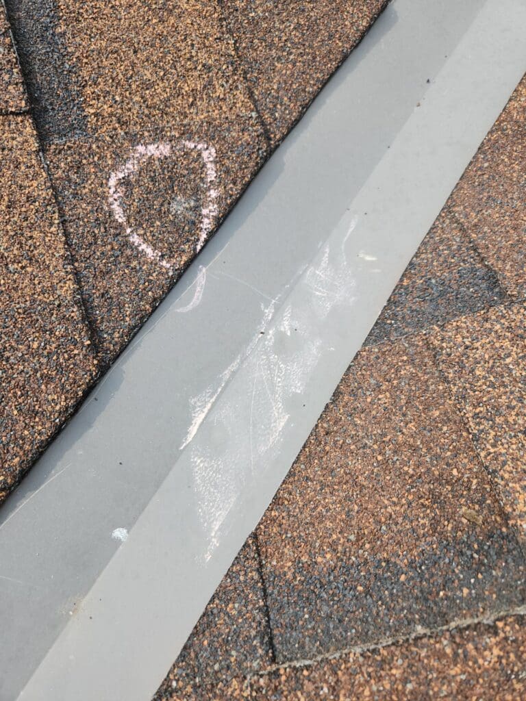 Roof metal valley flashing damaged from hail