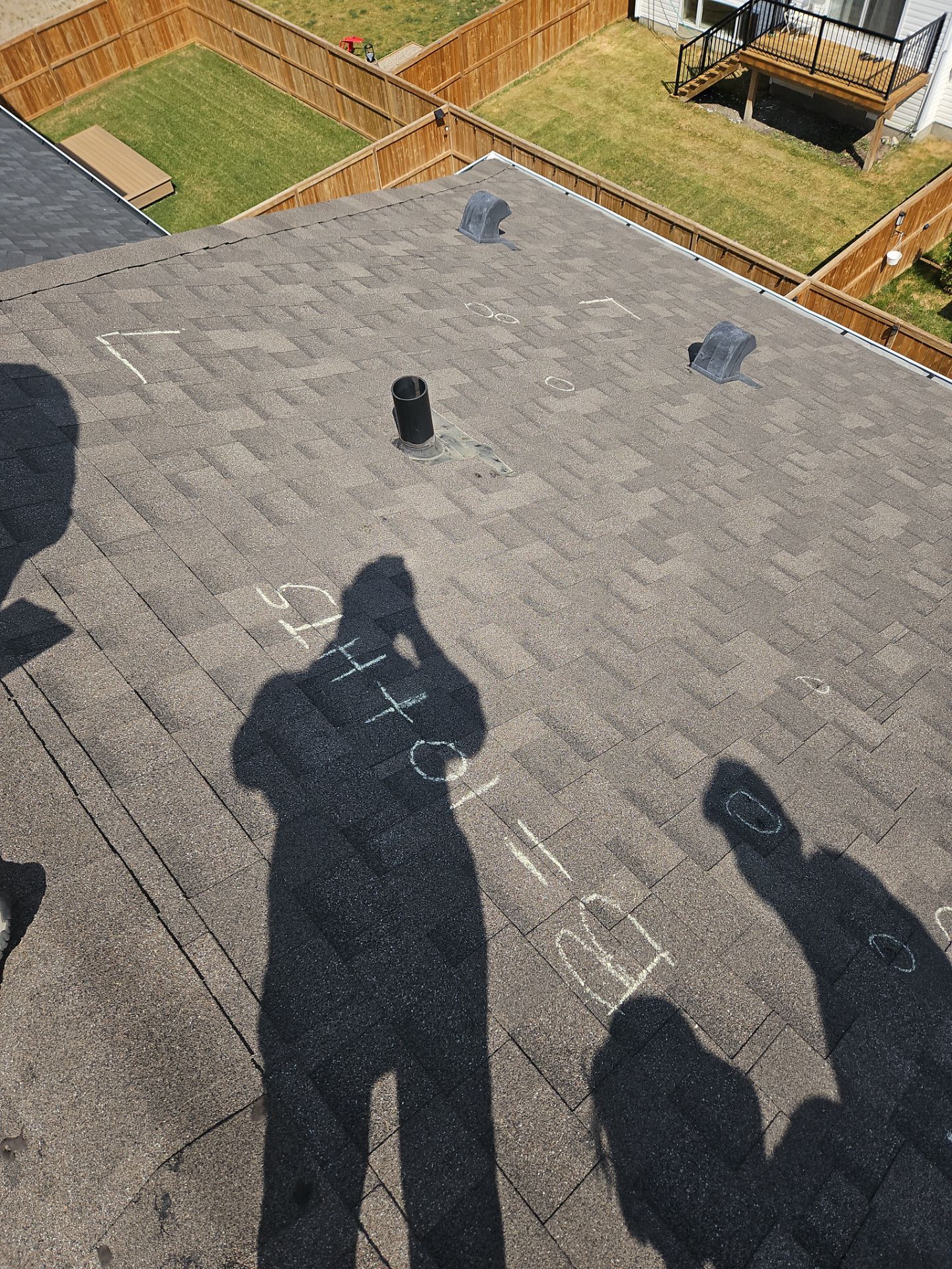 showing a chalked 10x10 square and chalked circles pinpointing hail damage to sloped shingled roof in Carrington Close NW, Calgary