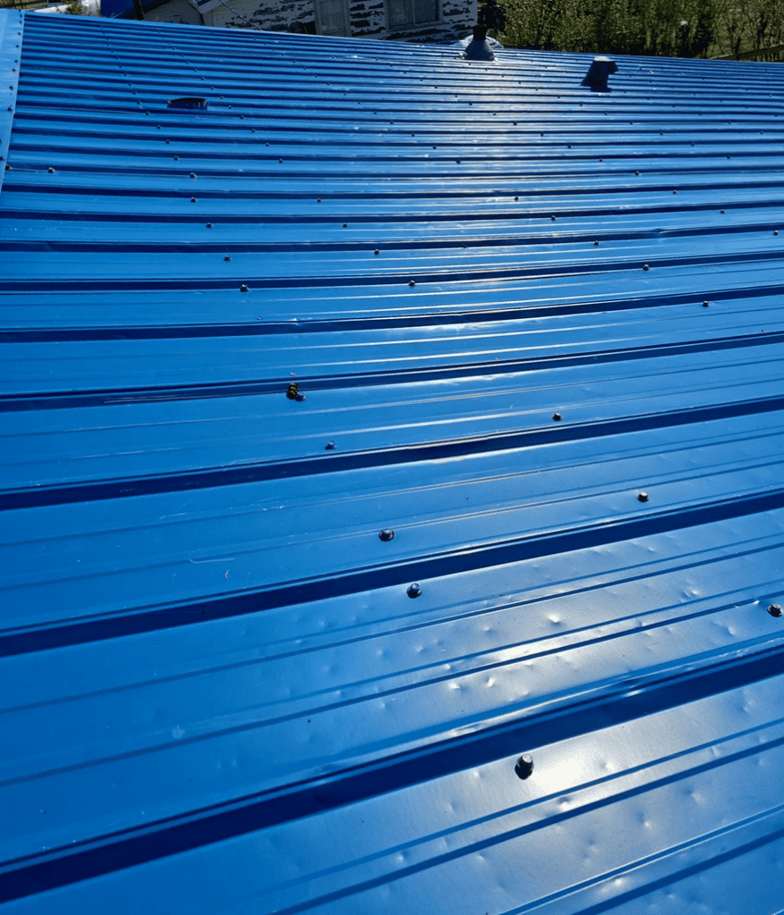 Sunny weather exposing hail dents to blue metal roof much effectively