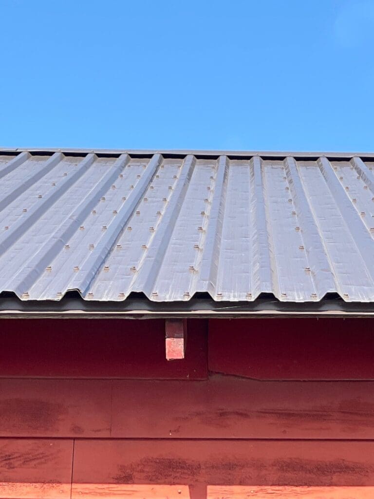 Viewing a sloped metal roof at a low angle where sunlight creates shadows/reflections across the panels